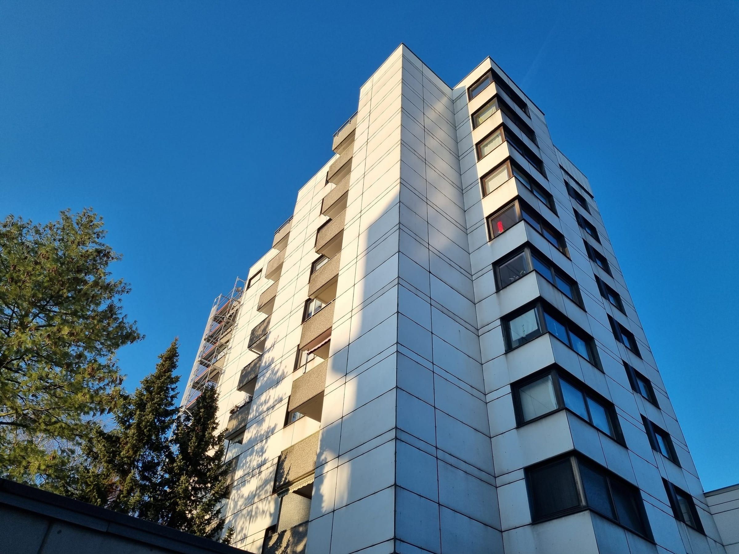 Zehngeschossiges Wohnhaus vor blauem Himmel