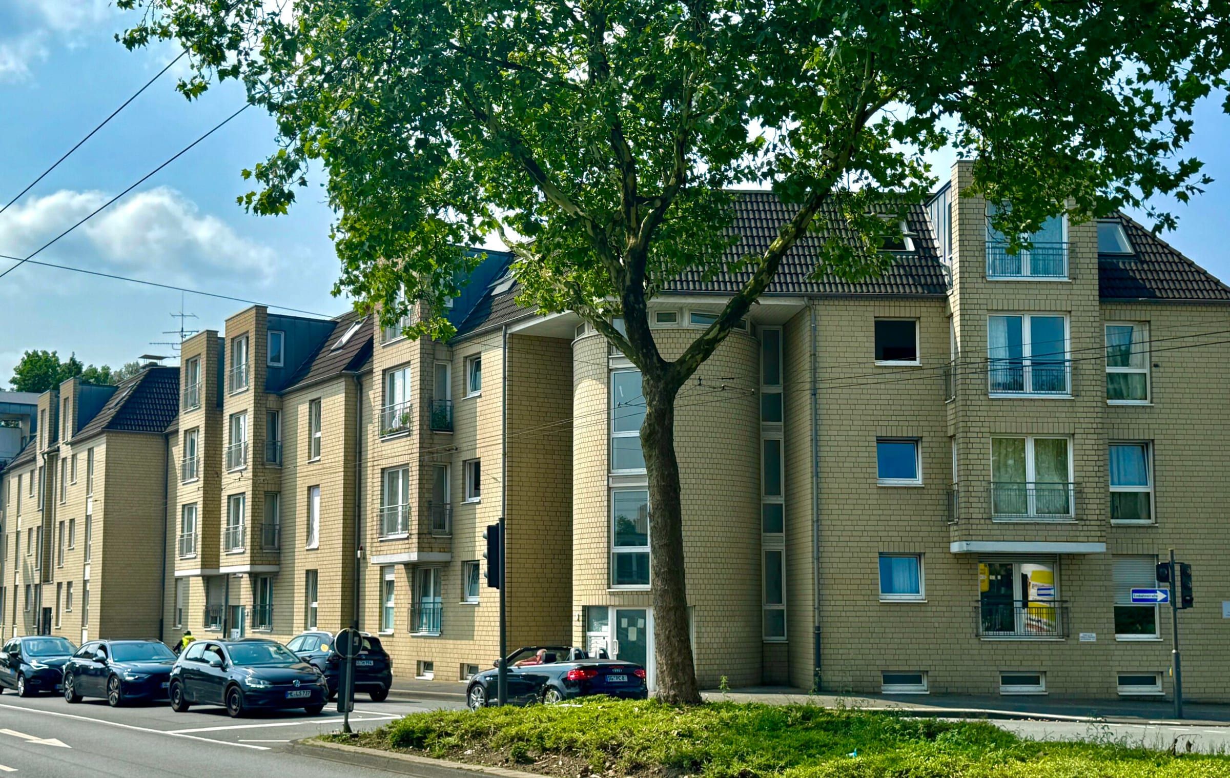 Helle Wohnanlage mit großem Baum davor