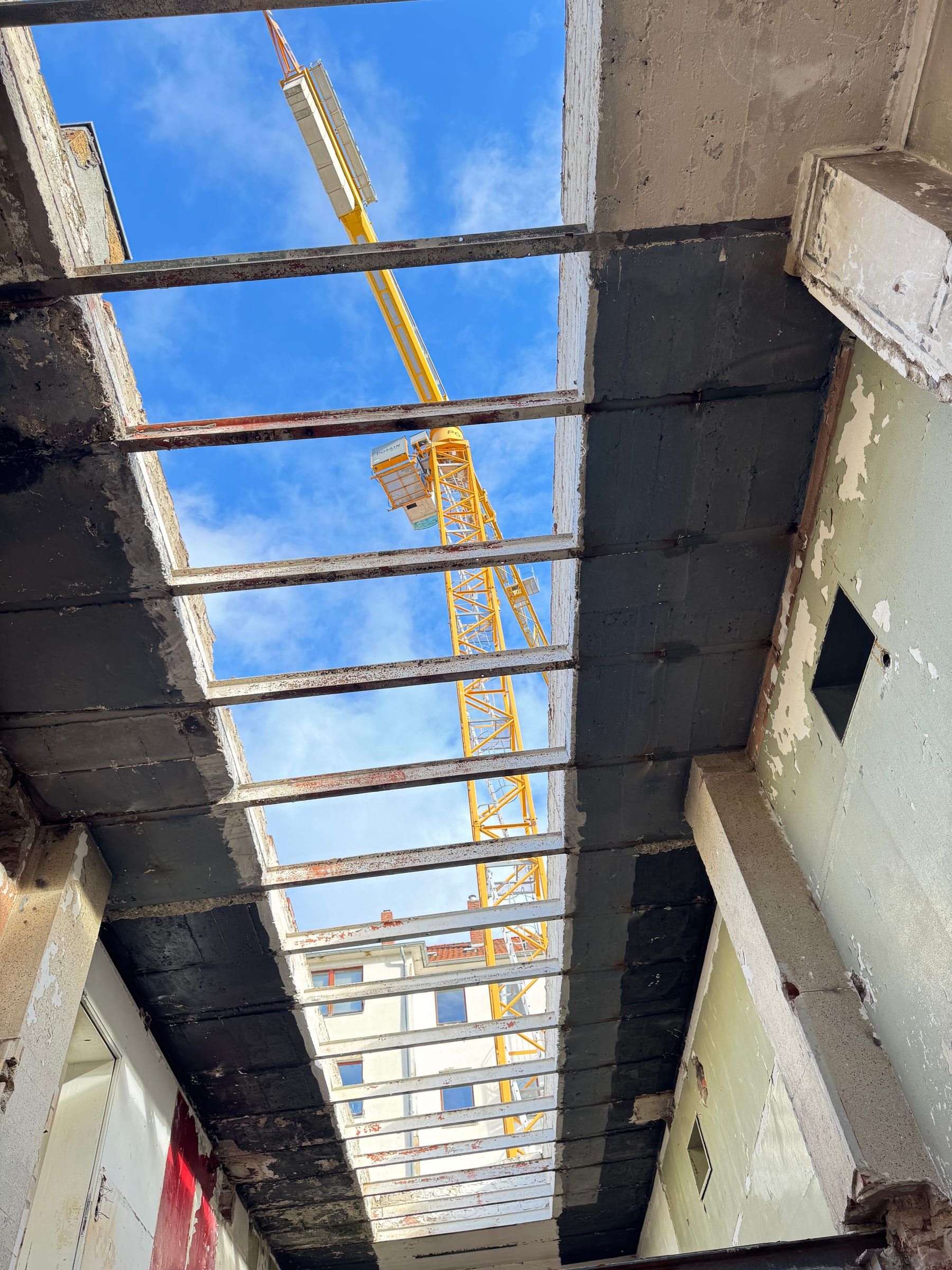 Alte Dachkonstruktion der Halle, dahinter ein Kran