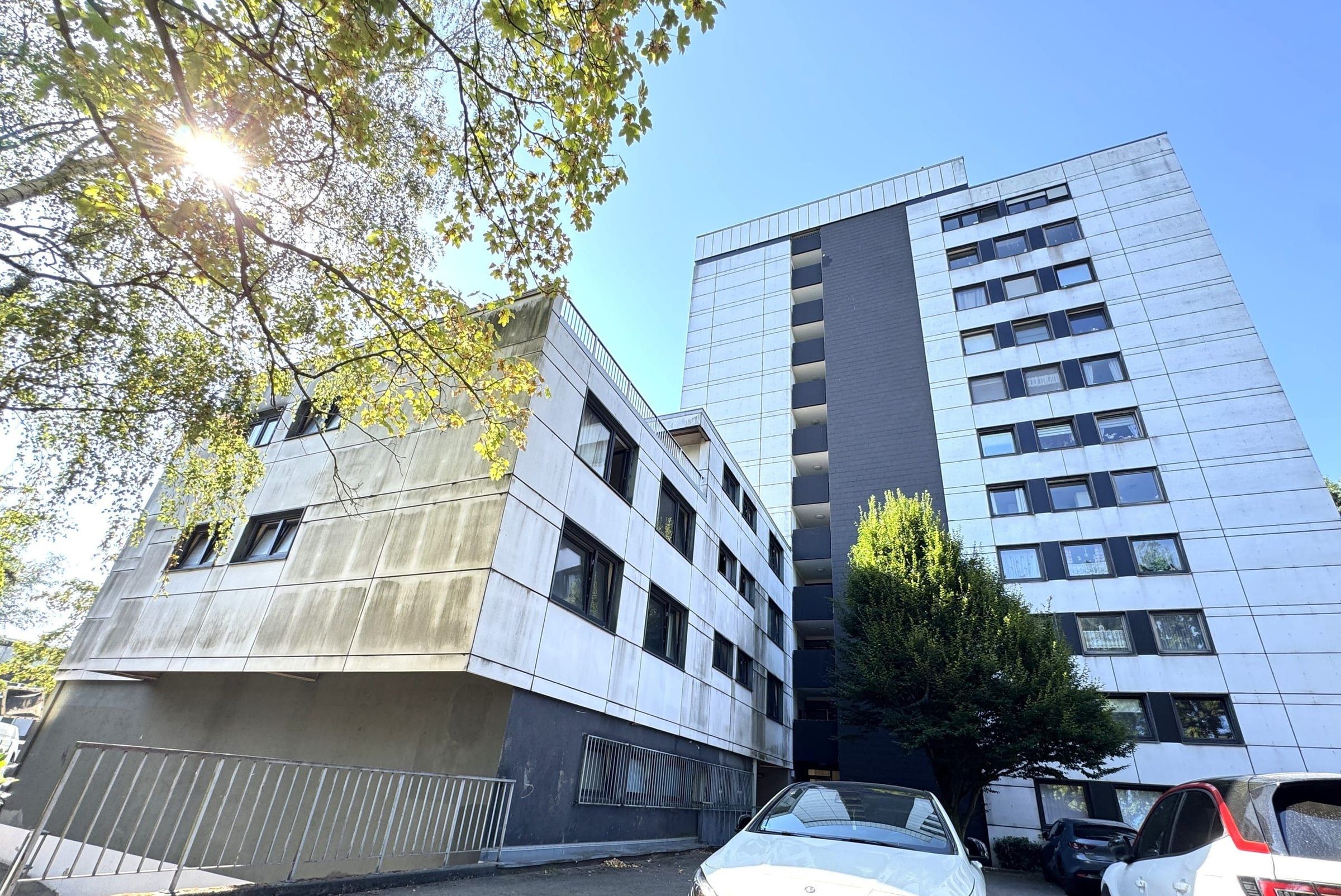 Rückseite mit Garten, dahinter das Hochhaus