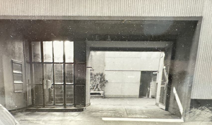 Altes Schwarz-Weiß-Foto vom Eingang der Halle mit der Skulptur des Schmieds